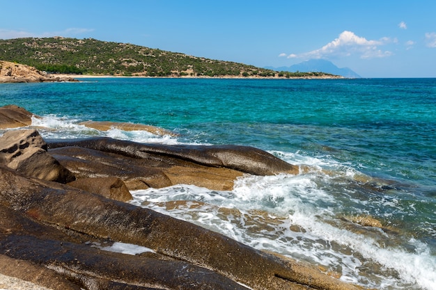 Foto bellissimo paesaggio con il mare, la roccia e le bellissime nuvole nel cielo azzurro