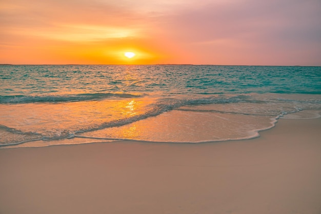 ビーチに沈む夕日の美しい風景。穏やかな波の砂浜の海岸。スカイラインの海景の地平線