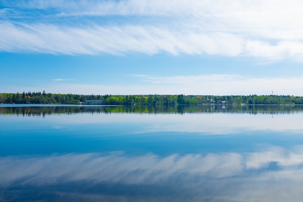 Photo beautiful landscape with sky, water and clouds with forest on the horizon