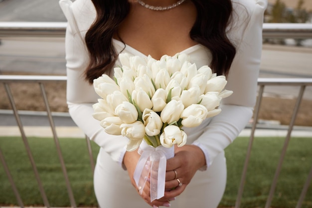 신부의 손에 있는 아름다운 큰 흰색 튤립 꽃다발