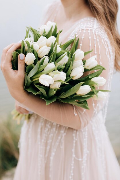 Beautiful large bouquet of white tulips in the hands of the bride