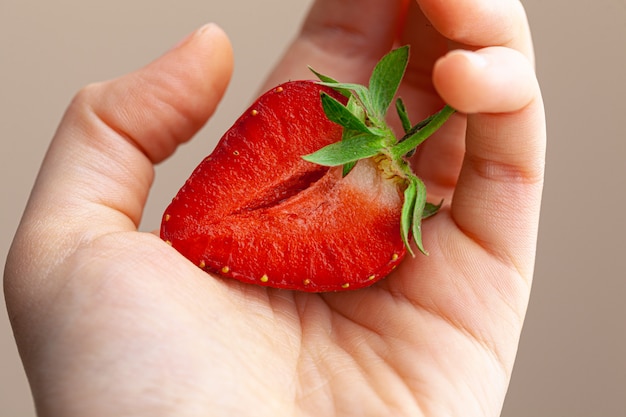 Bella grande fragola rossa in una mano. avvicinamento.