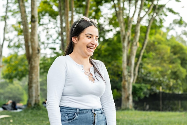 Beautiful latin girl smiling with laughter while taking a walk in the park