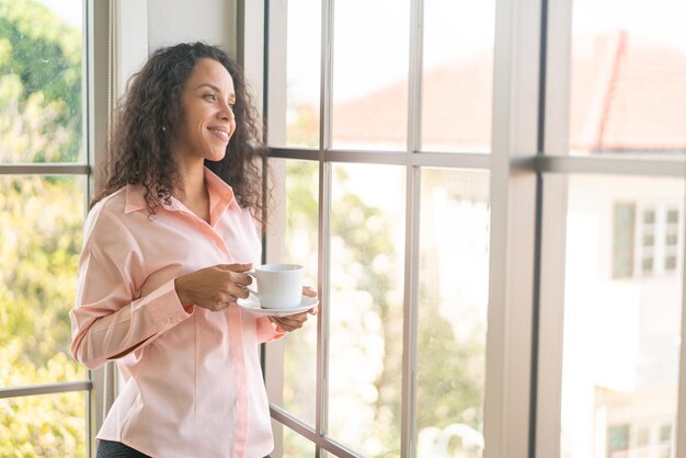 朝のコーヒーを飲む美しいラテン女性