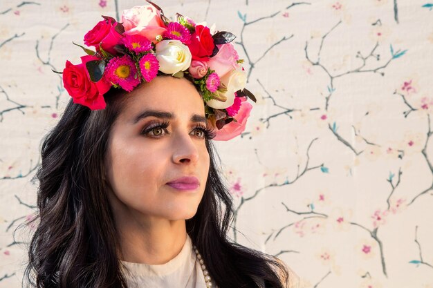 Beautiful latin woman with flowers. Stunning girl with big bouquet flowers of roses. Closeup face of beautiful woman with a healthy clean skin