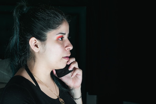 Красивая латиноамериканка с зелеными волосами получает звонок на свой мобильный телефон с ленивым выражением лица