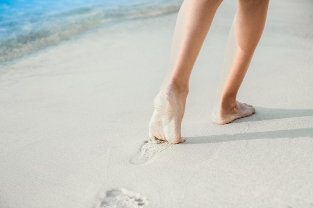 写真 ギリシャの海の砂の上に立つ美しい足