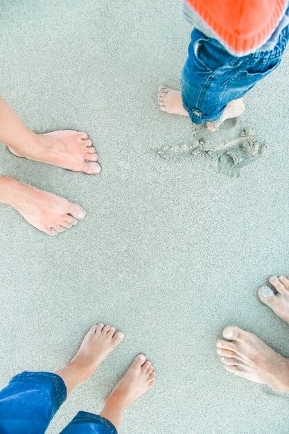 Foto belle gambe sulla sabbia vicino al mare sullo sfondo della natura