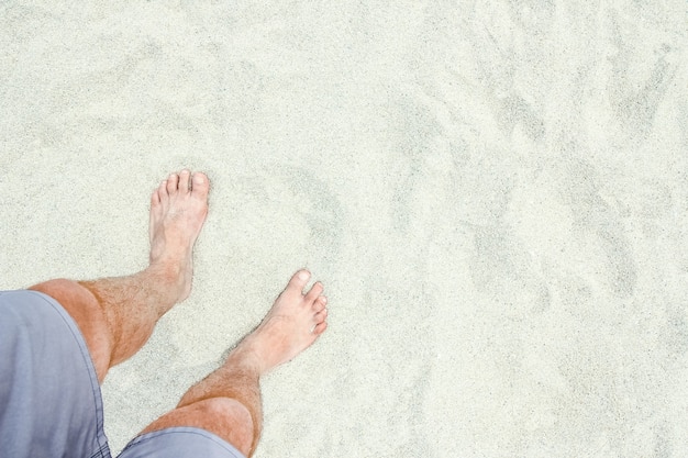 Beautiful legs in the sand of the sea greece background