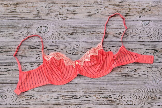 Beautiful light red bra on wooden table