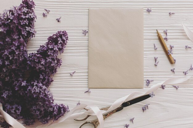 Beautiful lilac flowers greeting card vintage scissors on white rustic wood flat lay copy space