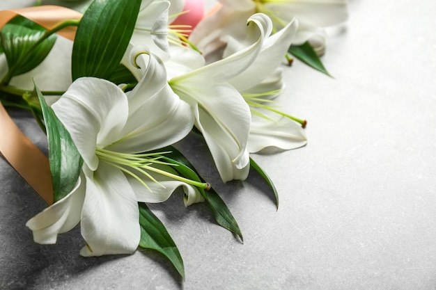 Beautiful lilies eggs and ribbon on gray background