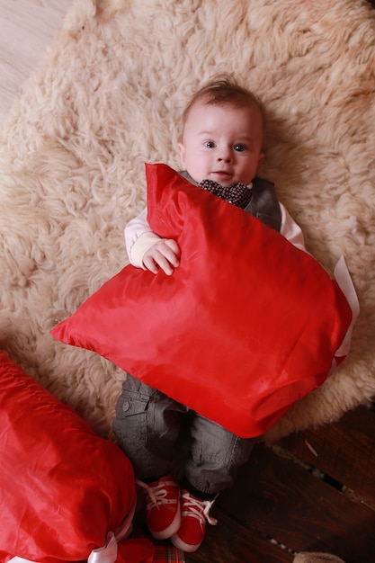 Beautiful little baby boy celebrates Christmas. New Year's holidays. Baby with gift.