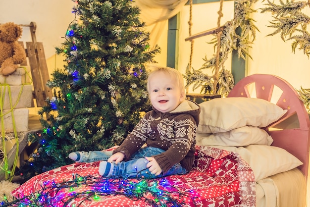 Beautiful little baby celebrates Christmas. Baby in a Christmas costume