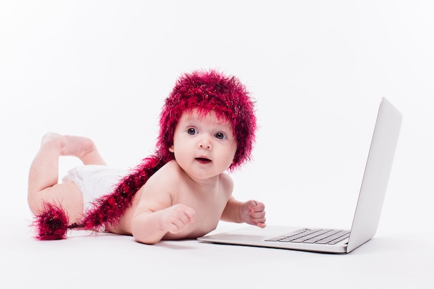 A beautiful little baby girl lying naked on her stomach on whi