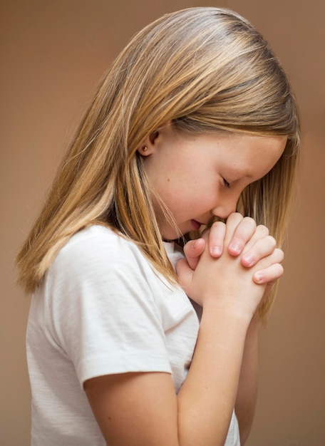 Photo beautiful little blonde girl praying