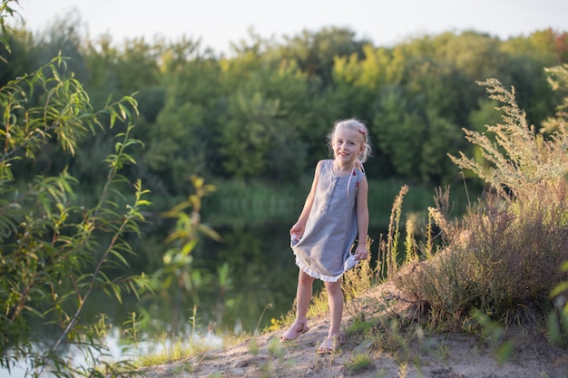 Beautiful little blonde girl on summer beach