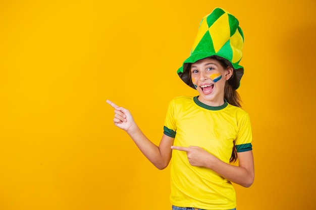 Beautiful little Brazilian fan girl pointing to the side