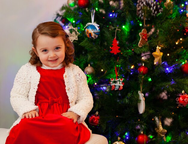 Beautiful little child near Christmas tree.