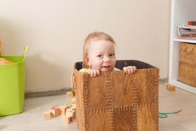 Beautiful little child plays with wooden cubes