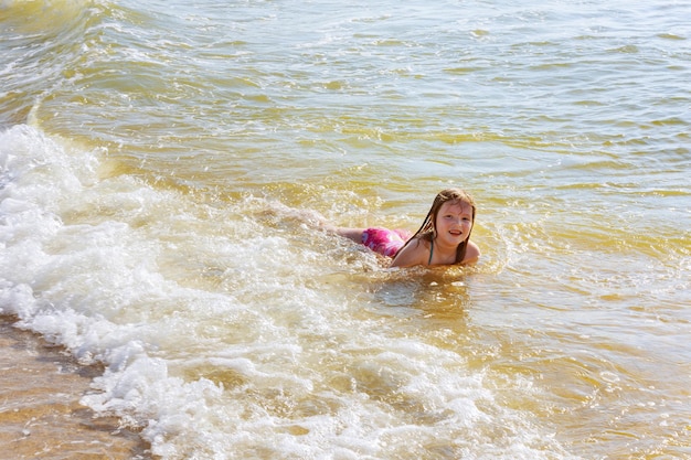 海で遊ぶ海の子供を浴びる美しい少女