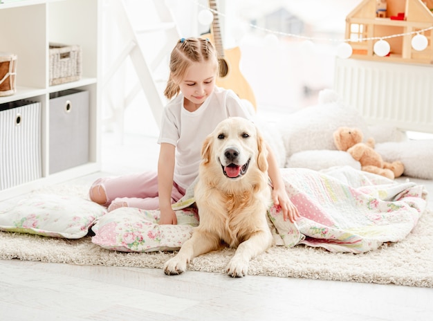 Beautiful little girl covering cute dog