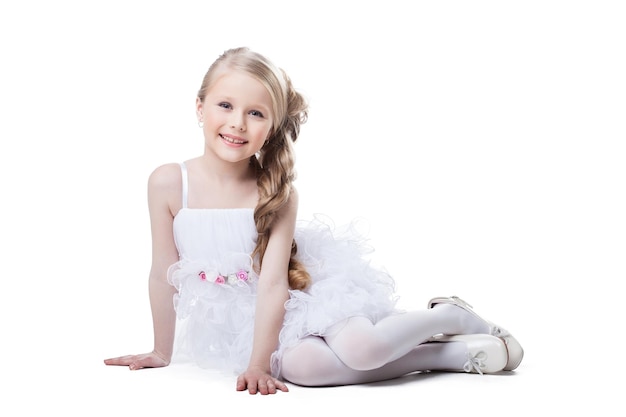 Beautiful little girl in dress sitting on floor