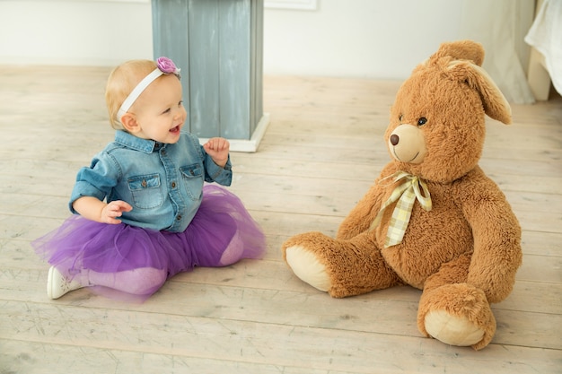 Bella bambina in un vestito elegante con un peluche