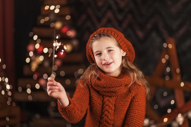 Beautiful little girl holding burning Bengal lights.