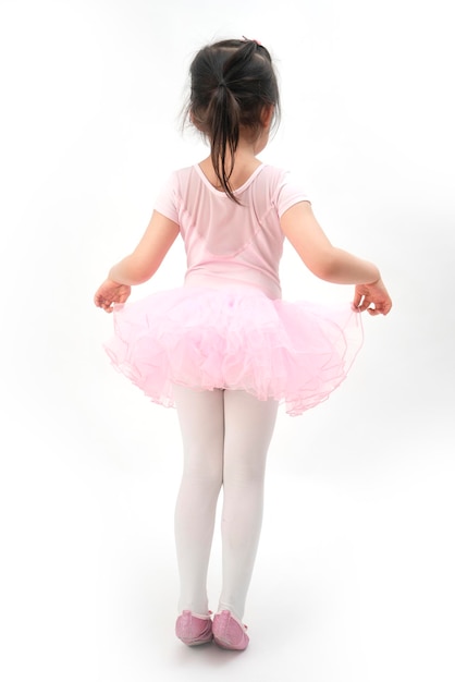 The beautiful little girl is doing gymnastics on a white background