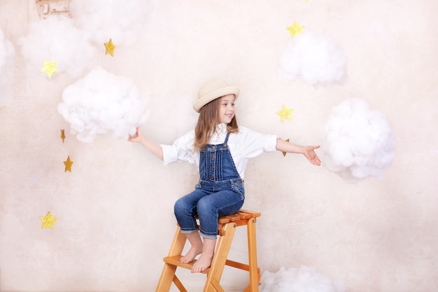 beautiful little girl near decorative clouds