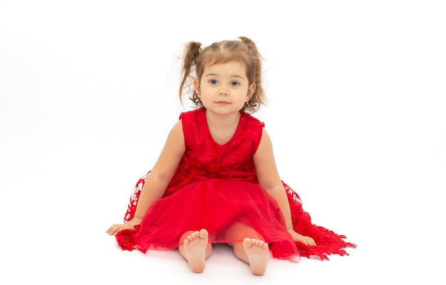 Beautiful little girl in red dress isolated on a white surface