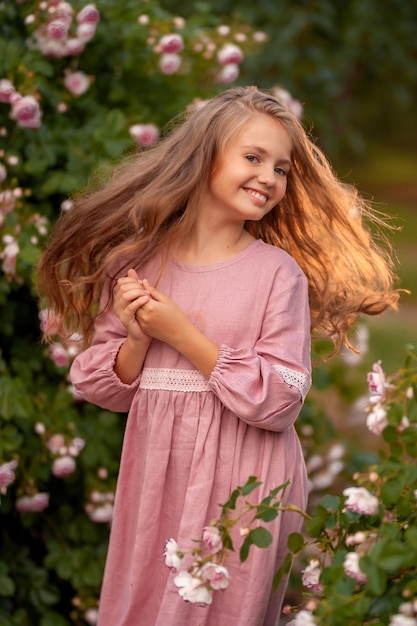 beautiful little girl next to roses