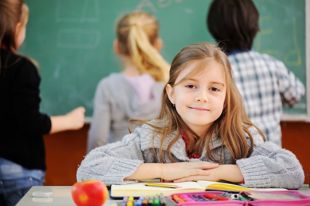 Beautiful little girl in school with her friends