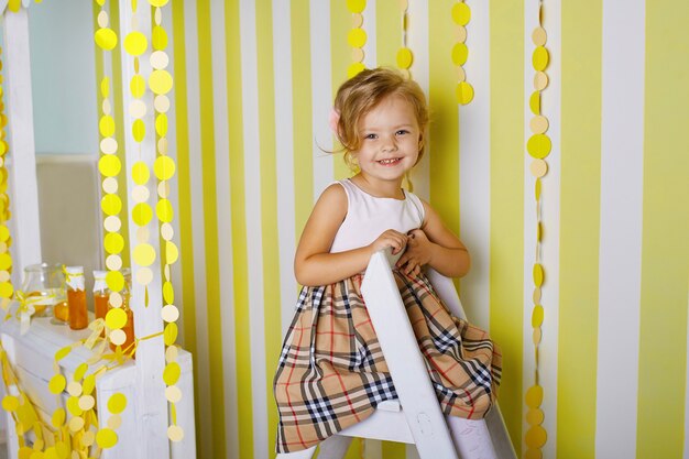 Bella bambina che si siede sulla scala a libretto.