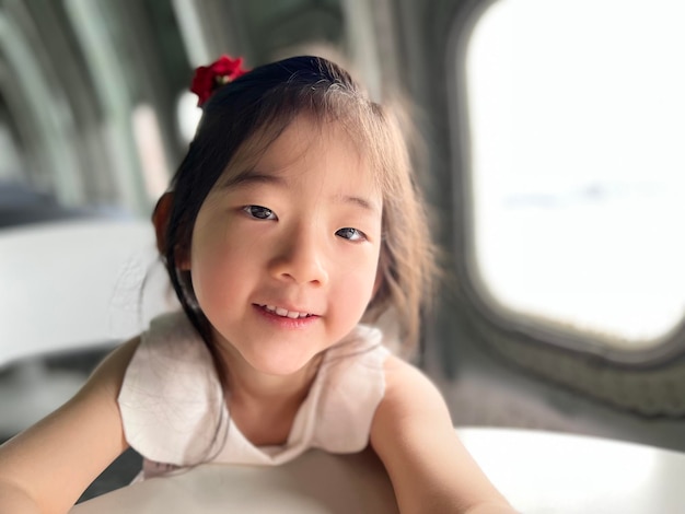 Beautiful little girl smiles on the table with white space background