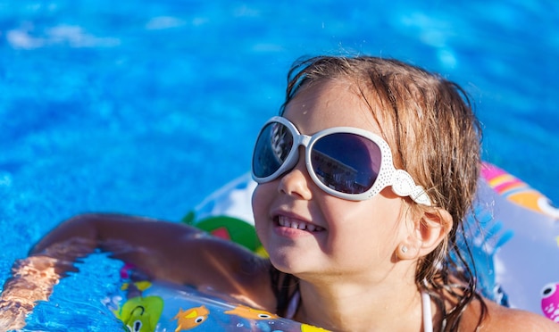 Beautiful little girl swimming at the pool