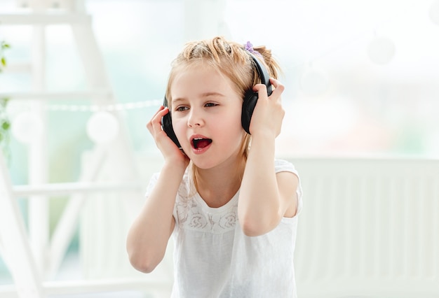 Beautiful little girl wearing headphones