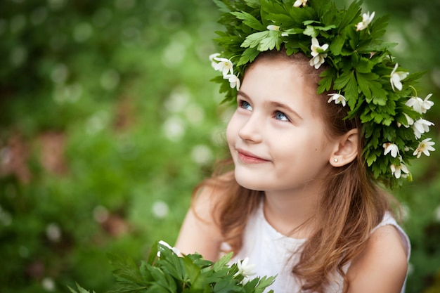 Beautiful  little girl in a white dress  in the spring wood. 