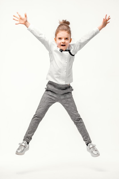 Beautiful little girl in white shirt and gray pants