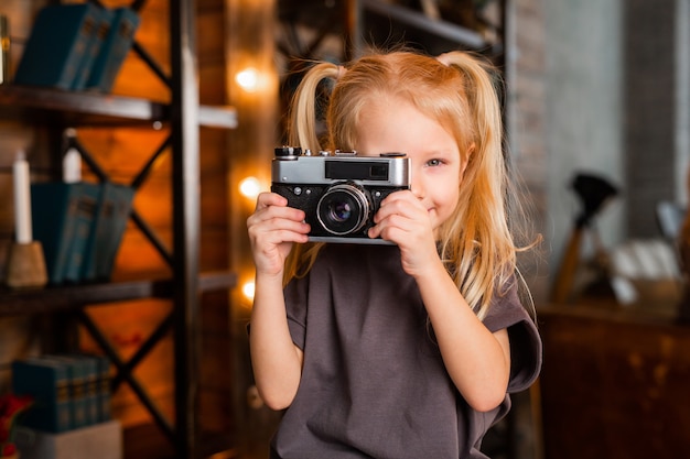 Foto bella bambina con una macchina fotografica