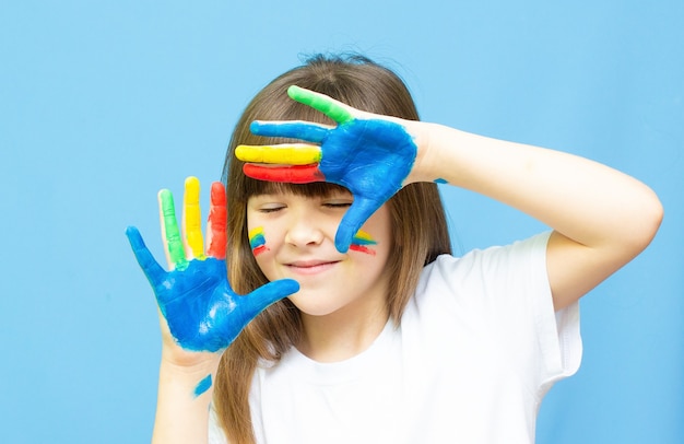 Beautiful little girl with her hands in the paint