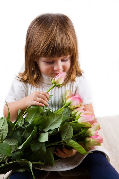 Beautiful little girl with roses flowers