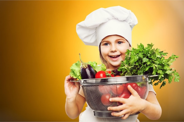 beautiful little girl with vegetables on a white background