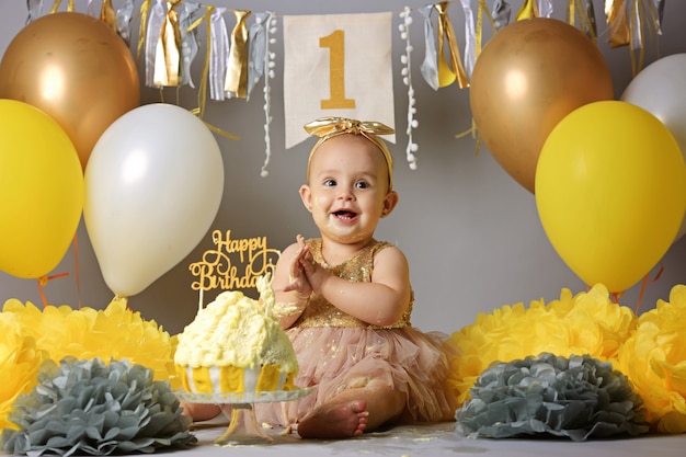 Bella bambina in abito giallo con torta dolce