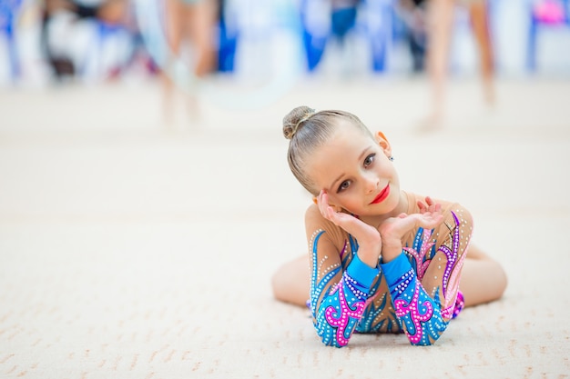 Beautiful little gymnast training on the carpet and ready for competitions