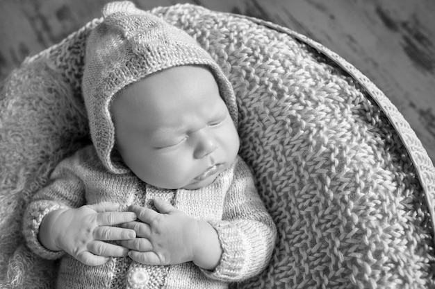 Beautiful little newborn boy 20 days sleeps in a basket Portrait of pretty newborn boy