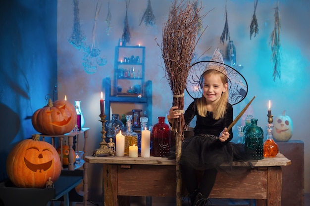 Красивая маленькая ведьма с украшениями на Хэллоуин