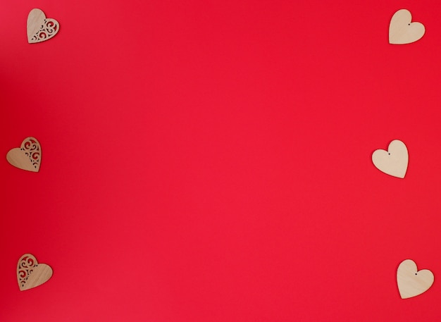 Beautiful little wooden hearts on red background