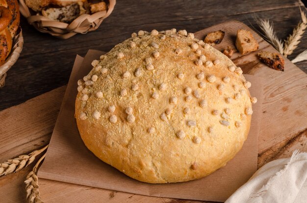 Beautiful loaf of white bread with a curly top on a wooden background